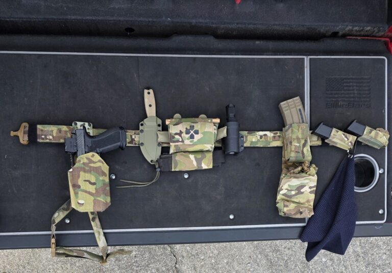 Complete first-line battle belt setup laid out after training, showing holster, magazines, medical gear, dump pouch, and support equipment