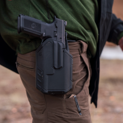 Pistol secured in a duty holster mounted on a first-line battle belt during live-fire training